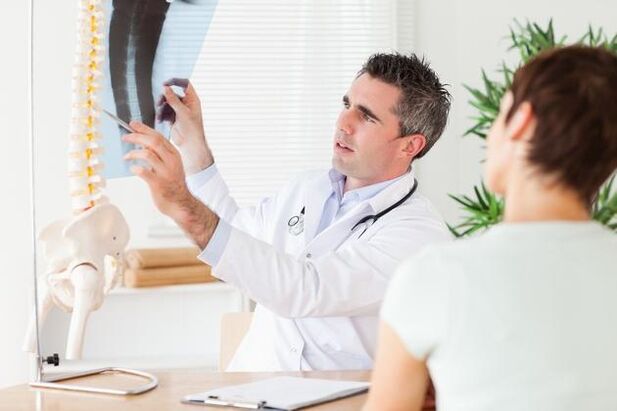 O médico mostra o dano na columna vertebral causado pola osteocondrose cervical